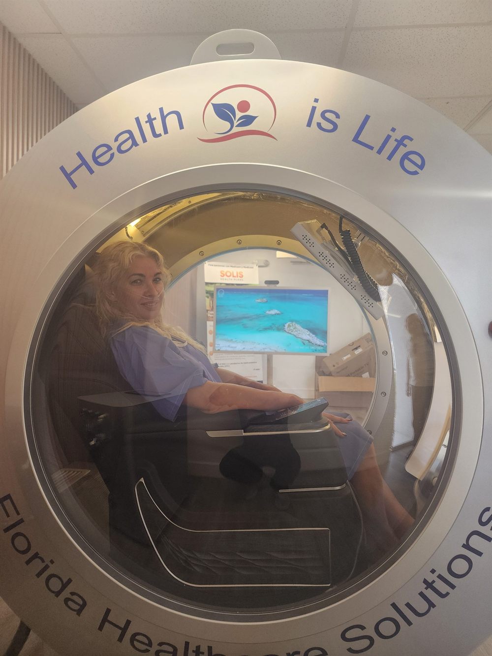 Patient seated inside the 2.0 ATA OxyEdge hyperbaric oxygen chamber at Florida Healthcare Solutions in Cutler Bay, Florida